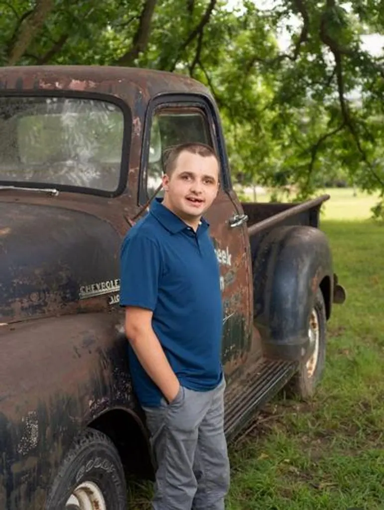 J.C. Ragsdale standing beside a vintage Chevrolet pickup truck.
